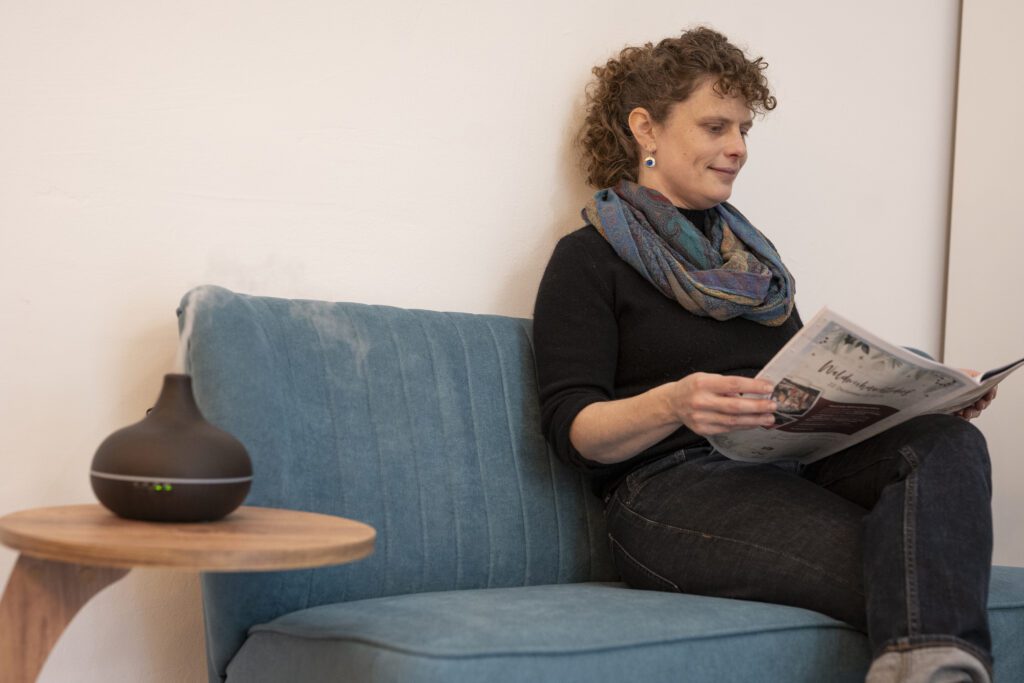 Patientin wartet in der Praxis und liest Zeitung